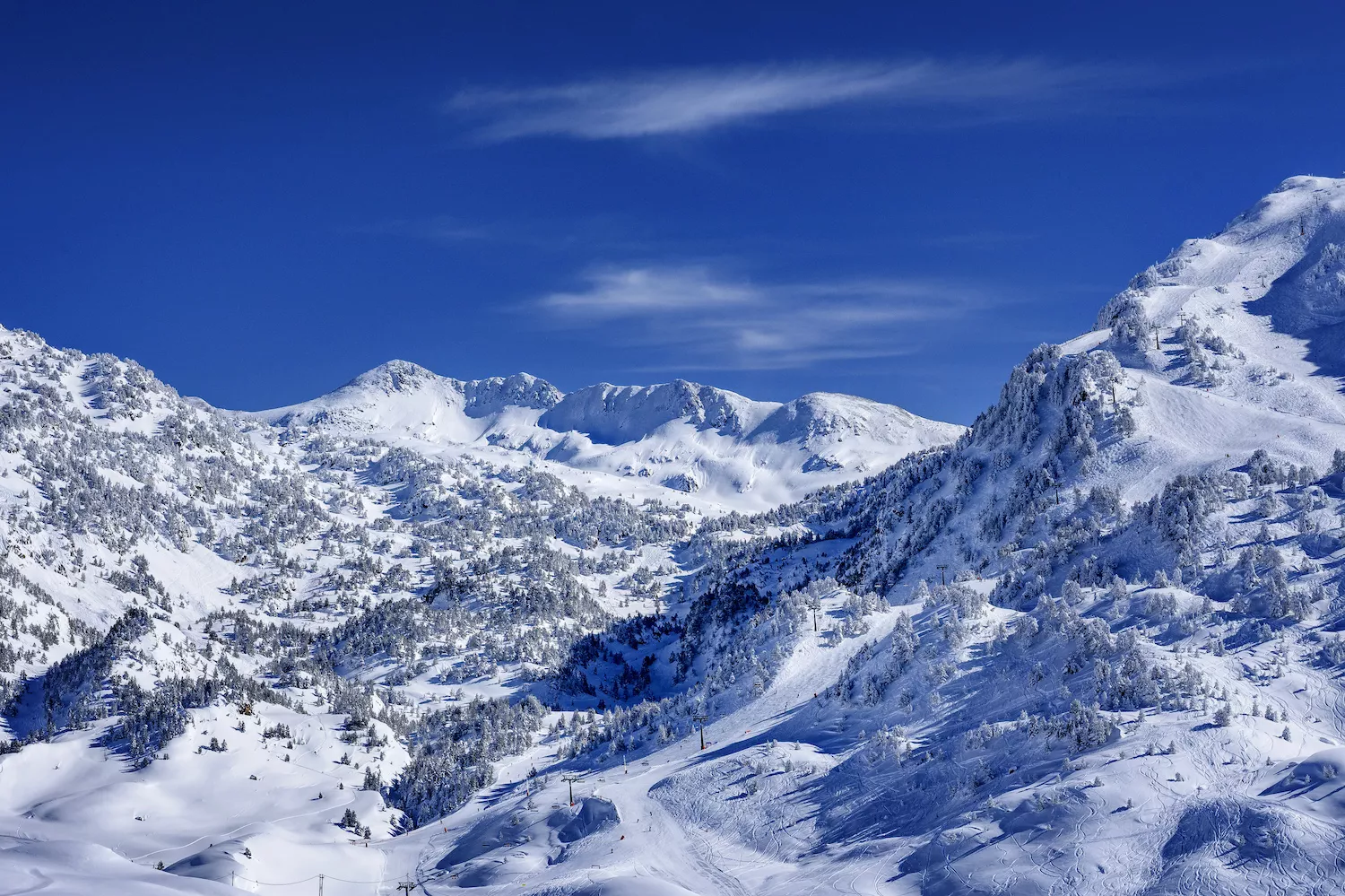 La llum del sol fa que la neu llueixi ben blanca, a la Vall d’Aran, en un racó a prop del naixement de la Garona