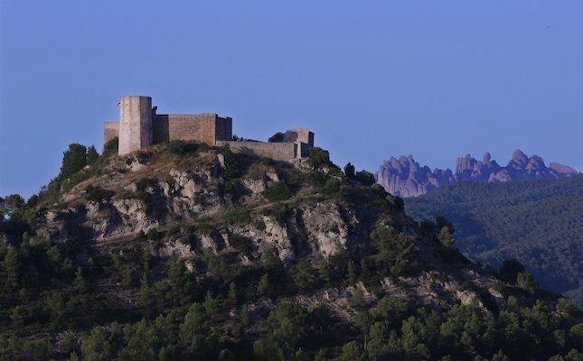 El castell de Claramunt, amb les muntanyes de Montserrat al fons 