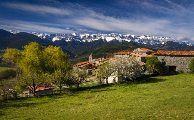 El poble de Lles de Cerdanya, amb la serra del Cadí com a teló de fons