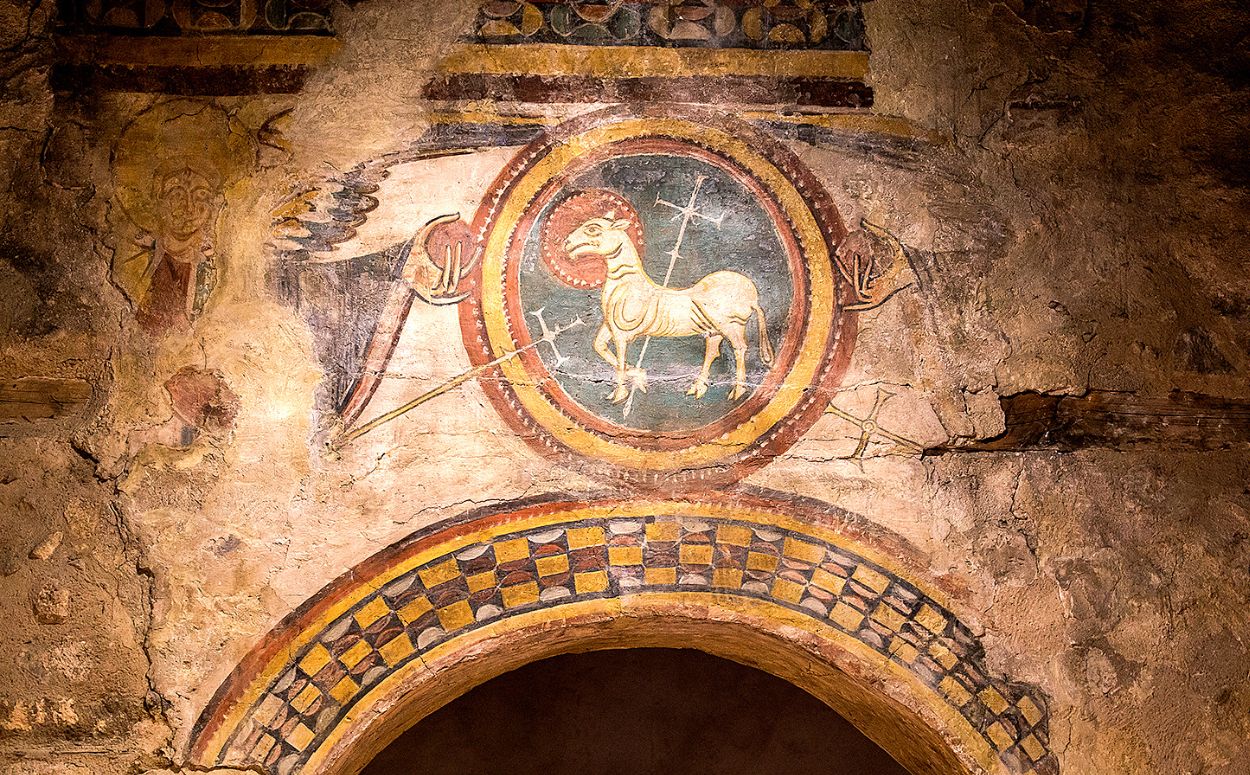 Detall de l'Agnus Dei que hi ha a l'arc triomfal de l'església de Santa Coloma.