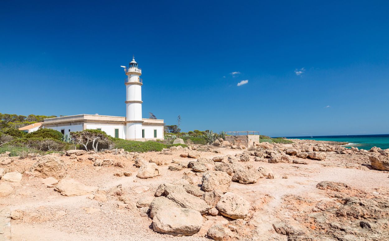 Far del cap de Ses Salines envoltat d’aigües cristal·lines