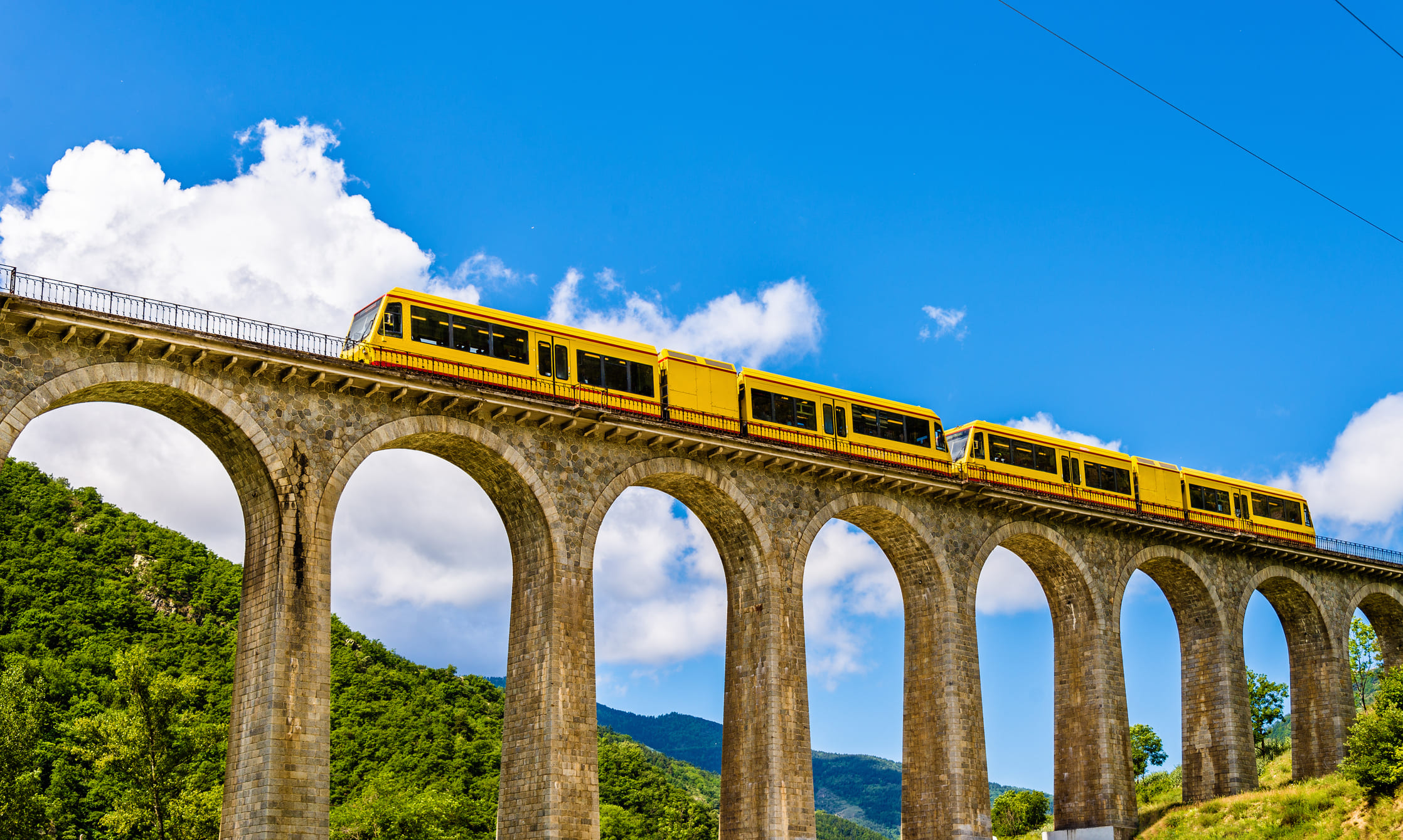 El tren groc al seu pas pel viaducte de Séjourné