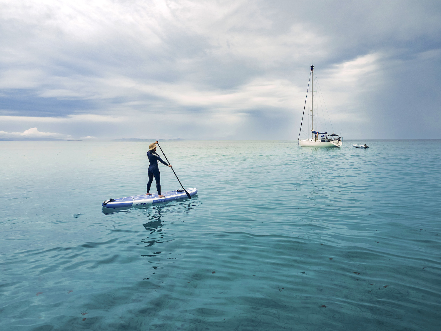 Tant és si fa una mica de fred: com que fa bona mar, l’Álvaro i la Caitlin agafen el neoprè i el surf de rem per navegar al voltant del veler