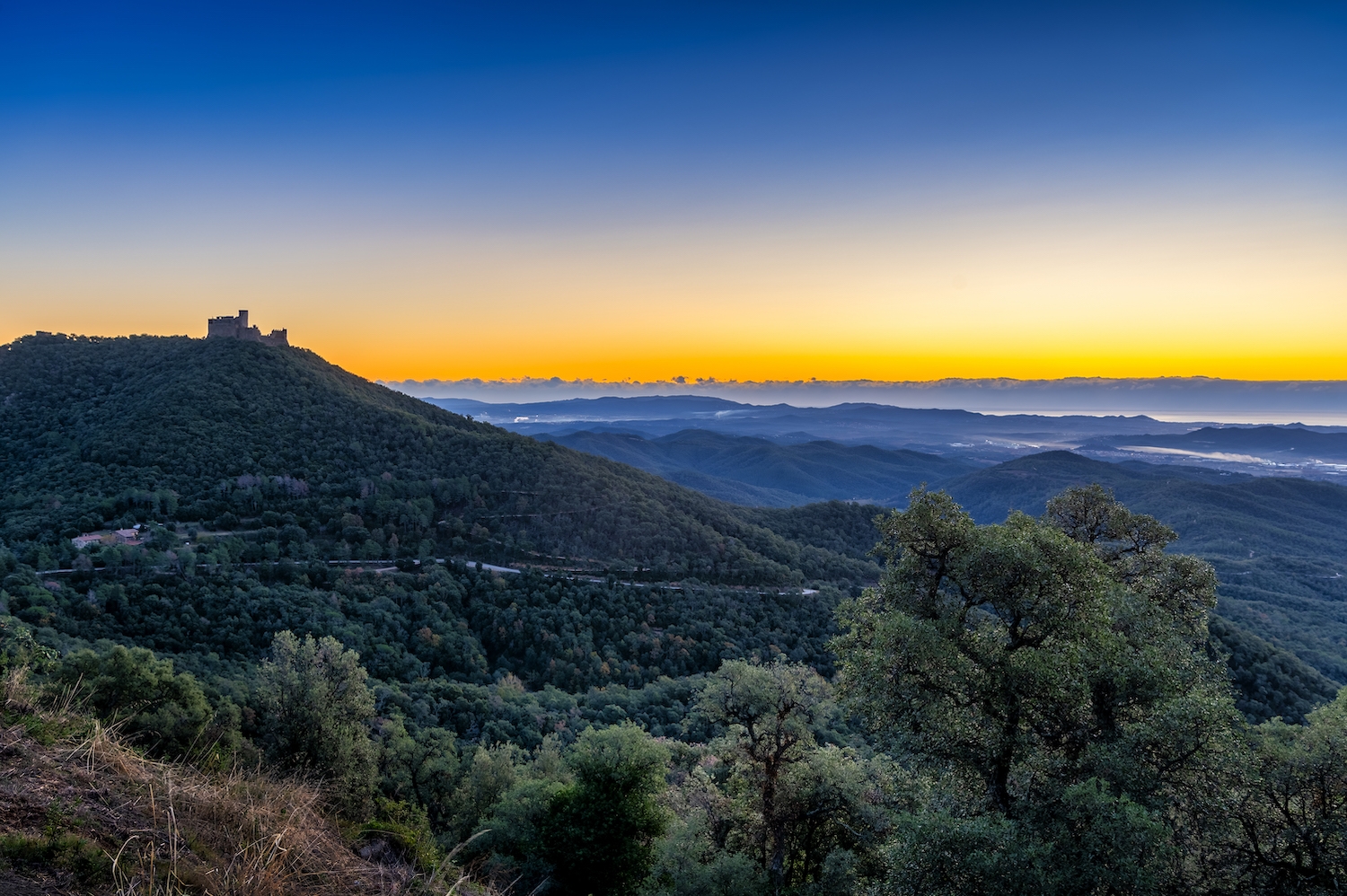 Sortida de sol des del mirador de Fogueres de Montsoriu, amb el perfil del castell