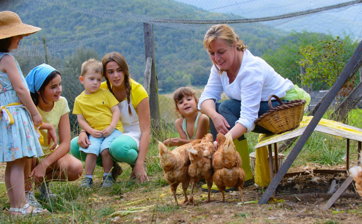 Família alimentant les gallines de l'allotjament Mas Garganta, a la Garrotxa