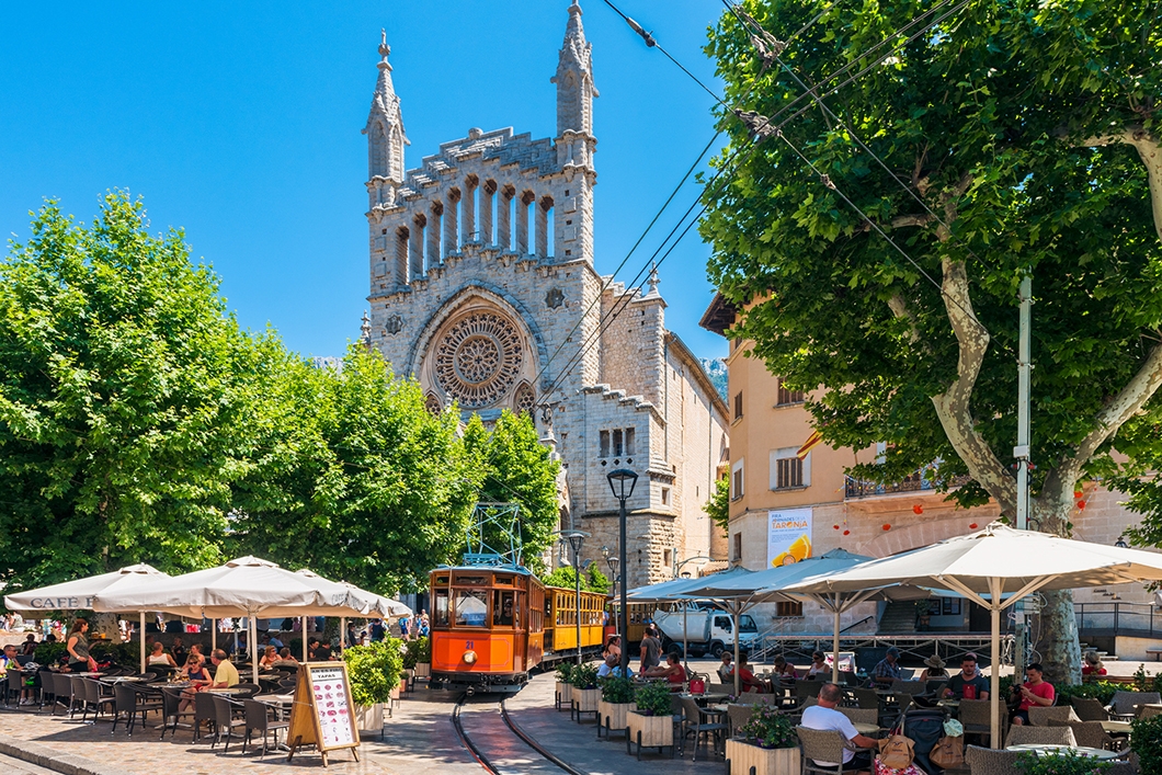 El tren de Sóller passant pels estrets carrers de la població.