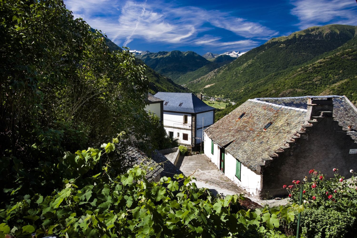 Des de Canejan, al cor de la Val de Toran, es veu el poble de Les i, al darrere, les geleres de la Maladeta i de Lis